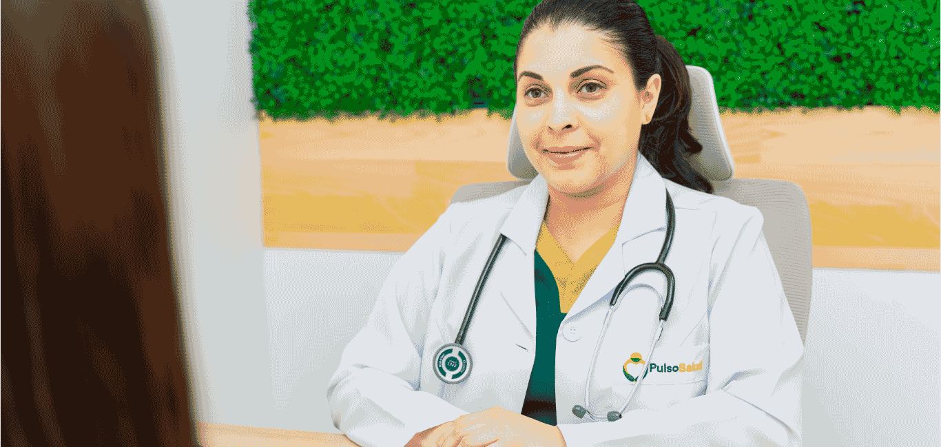 Doctora de Pulso Salud atendiendo a paciente en consulta médica, con bata blanca y estetoscopio, en un entorno profesional y acogedor.